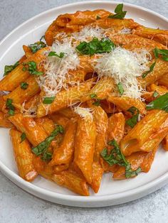 pasta with parmesan cheese and herbs on a white plate