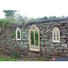 an old stone wall with three arched windows on each side and ivy growing on the rocks