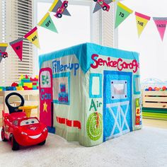 there is a play house with cars in the room