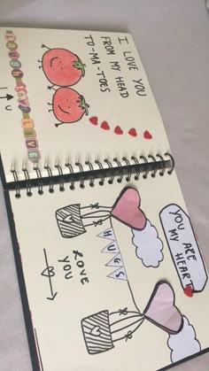 two notebooks with drawings on them sitting next to each other