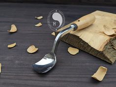 a spoon is sitting on top of a piece of wood