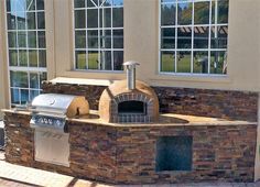 an outdoor pizza oven built into the side of a house