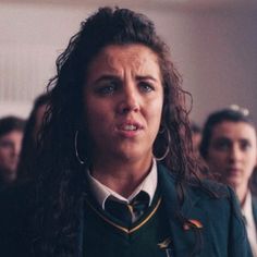 a woman in uniform standing next to other women and looking at the camera with an angry look on her face