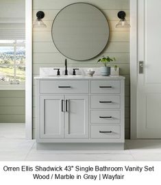 a bathroom vanity with a round mirror above it