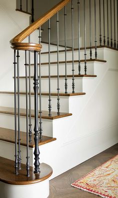 a wooden and metal stair case next to a rug