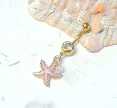 Starfish Belly Ring Show off your beautiful belly! Belly ring features a textured golden starfish charm with sparkly pink enamel accented with a hand wire wrapped pink agate bead. Belly button ring measures 1 3/4 inches long total length. Barbell is 14g gold plated surgical steel with a 10mm wearable bar length. For Belly Button Rings: https://www.etsy.com/shop/AllAboutClass?section_id=18474235&ref=shopsection_leftnav_1 For Industrial Barbells: https://www.etsy.com/shop/AllAboutClass?ref=l2- Pretty Piercings, Pink Starfish, Bellybutton Piercings, Starfish Jewelry, Belly Piercing Jewelry, Gold Belly Ring, Button Piercing, Belly Button Jewelry, Dangle Belly Rings