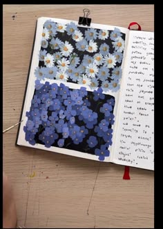 an open book with blue and white flowers on it