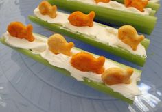 four pieces of celery with cheese and other toppings on them sitting on a plate