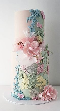 a multi - tiered cake decorated with flowers and lace