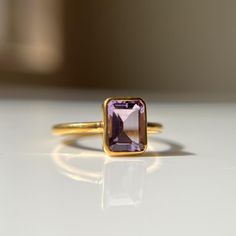 "Royal Purple" 8x6mm Octagon Amethyst Ring Elevate your style with our 18K gold Amethyst ring, featuring an 8x6mm octagon cut gemstone in a sleek bezel setting. Perfect for everyday wear or special occasions. Crafted with care in your choice of gold, this ring is a versatile accessory that complements any style, serving as a reminder of growth and progress in your journey. *Details:* * Dimensions:   ~ 1.5mm band width  ~ 1.3mm band height Gemstone - ~ Amethyst  - 8x6 mm Octagon Cut * Metal Options:  10k, 14k, 18k solid gold (yellow, rose, white); sterling silver; gold vermeil; Gold plated ( brass). *Why you'll Love and Treasure  it:* - Rare and vibrant Amethyst gemstone - Octagon cut for unique brilliance - Bezel setting adds modern flair - 18K rose gold provides durability and luxury feel Luxury Amethyst Ring With Bezel Setting, Luxury Classic Amethyst Ring With Bezel Setting, Purple Engagement Rings, Handcrafted Engagement Ring, Gold Amethyst Ring, Purple Reign, Birthstone Gifts, February Birthstone, Royal Purple