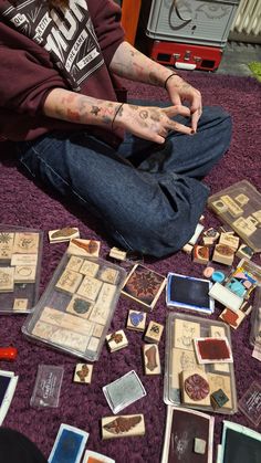 a man sitting on the floor surrounded by lots of cards and playing with his hands