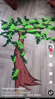 a drawing of a tree on the floor with green leaves and branches growing out of it