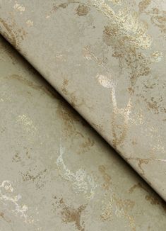 an old, dirty wallpaper with gold and silver paint splattered on it