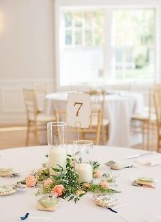 the table is set up with candles and flowers on it for an elegant wedding reception