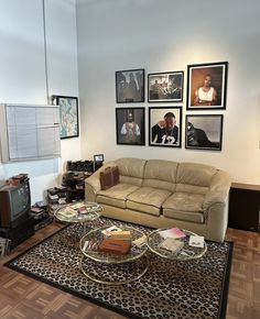 a living room filled with furniture and pictures on the wall above it's coffee table