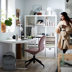 a woman standing next to a desk in a room