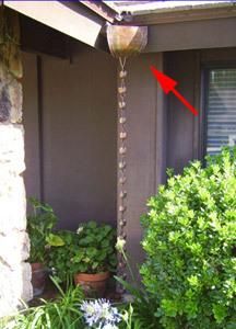 the corner of a house with plants and flowers