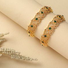 Description : This classic silver bangle is elegantly crafted from CZ stones on a gold-plated base finished with emerald green stones. Designed for grand events and with a luxe finish, this piece can be worn alone, or stacked with other bangles from the Nakshatra family. Product Information : Materials used : 925 Silver with 1.0-microns Gold Plating Stones: AAA grade CZ stones Length: 6 cm(2.6) Contains: Comes in a pair Luxury Jeweled Bangle For Festive Season, Elegant Jeweled Gold Bangle, Elegant Gold Jeweled Bangle, Elegant Green Bangle For Festive Occasions, Elegant Green Bangle With Stone Work, Green Jeweled Bangle Bracelets, Elegant Jeweled Bangle For Festive Occasions, Elegant Gold Bangle With Jewels, Gold Plated Jeweled Bracelets For Formal Occasions