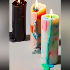 three colorful candles sitting next to each other