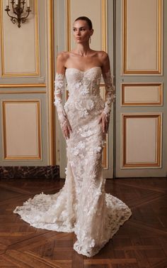 a woman in a white wedding dress standing on a wooden floor with her hands on her hips