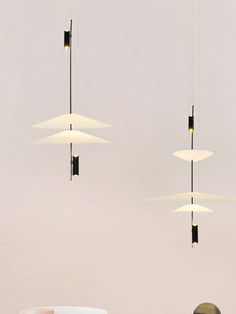 three lights hanging from the ceiling above a table