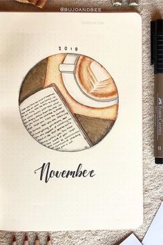 an open notebook with a coffee cup on it and the words november written in black ink