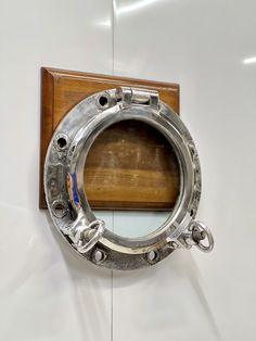 a porthole mirror mounted to the side of a wooden and metal ship's wall