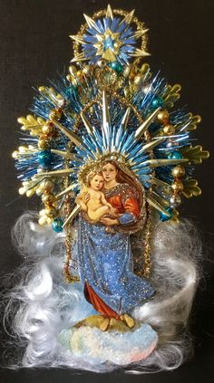 a statue of the virgin mary holding a baby jesus in front of a fireworks display