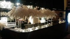 a bar with white feathers and wine glasses