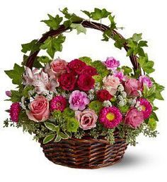 a basket filled with lots of flowers and greenery