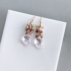 Free Shipping. Clear Rose Pink Quartz drop earrings made entirely by hand with real gemstones and 14k gold plated Italian silver. Very simple and easy to wear, these dangle earrings are perfect to throw on with anything and can be your everyday earring. They catch the light beautifully to add a hint of sparkle. STYLE DETAILS - Primary stone - Clear Pink Quartz - Gemstone Cluster - Mystic Rose Quartz, Pink Tourmaline, Champagne Quartz, Champagne Pearl - 1.5 inches long - French hooks with safety Gold Briolette Crystal Earrings For Wedding, Fine Jewelry Briolette Earrings For Wedding, Briolette Yellow Gold Earrings For Weddings, Wedding Gemstone Drop Earrings, Yellow Gold Briolette Earrings For Wedding, Wedding Drop Gemstone Earrings, Wedding Drop Jewelry With Gemstone Accents, Briolette Wedding Earrings Fine Jewelry, Briolette Gemstone Earrings For Wedding