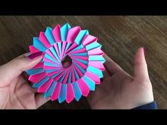 someone is holding up a colorful origami piece