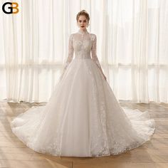 a woman in a white wedding dress standing on a wooden floor next to a window