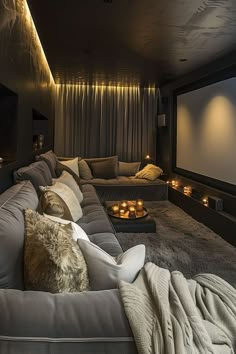 a living room filled with lots of couches and candles in front of a projector screen