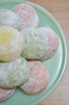 several powdered donuts on a green plate