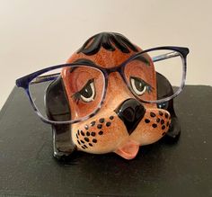 a ceramic animal with glasses on it's head sitting on a black counter top