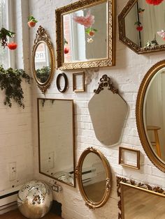 A brick wall with various shaped mirrors, a disco ball on the ground in the corner, and hanging flowers from the ceiling Disco Decor Aesthetic, Disco Ball Mirrors, Dit Disco Ball, Disco Ball Decor Bathroom, Disco Ball In Apartment, Disco Apartment Decor, Vintage Disco Ball Aesthetic, Disco Nursery, 70s Apartment Aesthetic