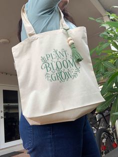 This beautiful plant bloom grow shopping tote bag made with 100% organic cotton, has intentionally handles reinforced. You can use this bag also for a visit to the library, day at the beach or a day of grocery shopping. Surprise a friends, maid of honor, bridesmaid, mother or any family loved one with this aesthetic organic tote bag! Tote Canva Bag Durable 6-ounce, 100% certified organic cotton tote bags Chemical Free Organic cotton handles reinforced with stress-point stitching Expandable botto Botanical Style Rectangular Cotton Canvas Bag, Botanical Cotton Canvas Tote Bag, Botanical Cotton Canvas Bag For Everyday Use, Eco-friendly Canvas Bag For Mother's Day, Botanical Cotton Canvas Bag For Daily Use, Eco-friendly Cotton Canvas Bag For Mother's Day, Botanical Cotton Tote Bag, Botanical Style Cotton Tote Bag, Green Cotton Canvas Bag For Gift