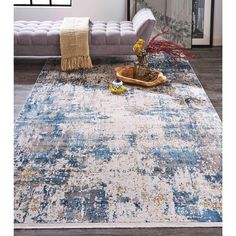 a living room area with a couch, rug and coffee table on the floor in front of it