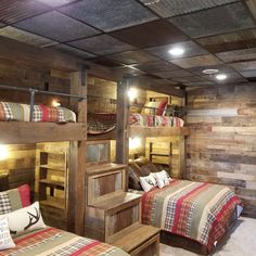 two beds in a room with wooden walls and bunk beds on each side, one is made out of wood planks