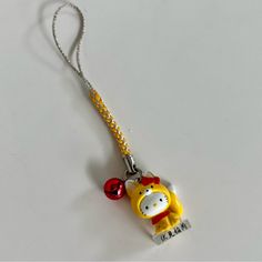 a keychain shaped like a cartoon character with a hello kitty charm attached to it