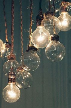 a bunch of light bulbs hanging from a chandelier in a black and white photo