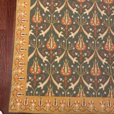 a green rug with orange and white designs on it