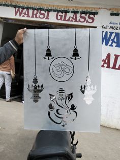 a man holding up a sign with an image of ganesh on it