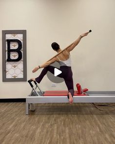 a woman is doing pivots on a table with a machine in front of her