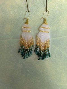 Gold, white and green fringe earrings with gold colored ear wires. White Fringe Beaded Dangle Earrings, White Fringe Dangle Chandelier Earrings, White Fringe Tassel Earrings As Gift, White Beaded Fringe Drop Earrings, White Fringe Chandelier Dangle Earrings, White Tassel Beaded Drop Earrings, White Fringe Tassel Drop Earrings, White Tassel Chandelier Drop Earrings, Pink Bracelet