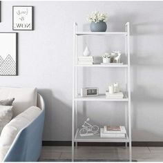 a living room with white furniture and pictures on the wall above it, along with a blue chair