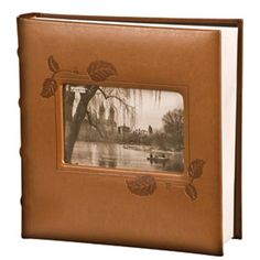 an old photo album with leaves on the front and bottom cover is shown in brown leather