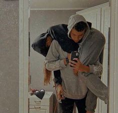 a man is taking a selfie in the mirror with his cell phone as he stands next to a woman