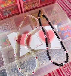 the beads are laying on top of each other in plastic storage containers with cards attached to them